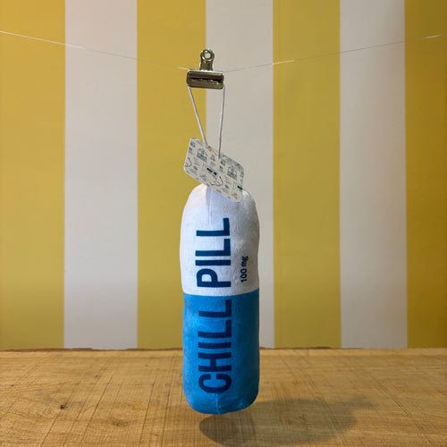 The Tetbury Pet Shop & Grooming's Chill Pill is a plush blue and white capsule toy for dogs, labeled "CHILL PILL" and hanging from a clip—perfect as a quirky squeaky toy for your pup.