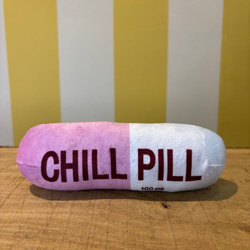 The Tetbury Pet Shop & Grooming's Chill Pill is a plush pink and white capsule toy for dogs, labeled "CHILL PILL" and hanging from a clip—perfect as a quirky squeaky toy for your pup.