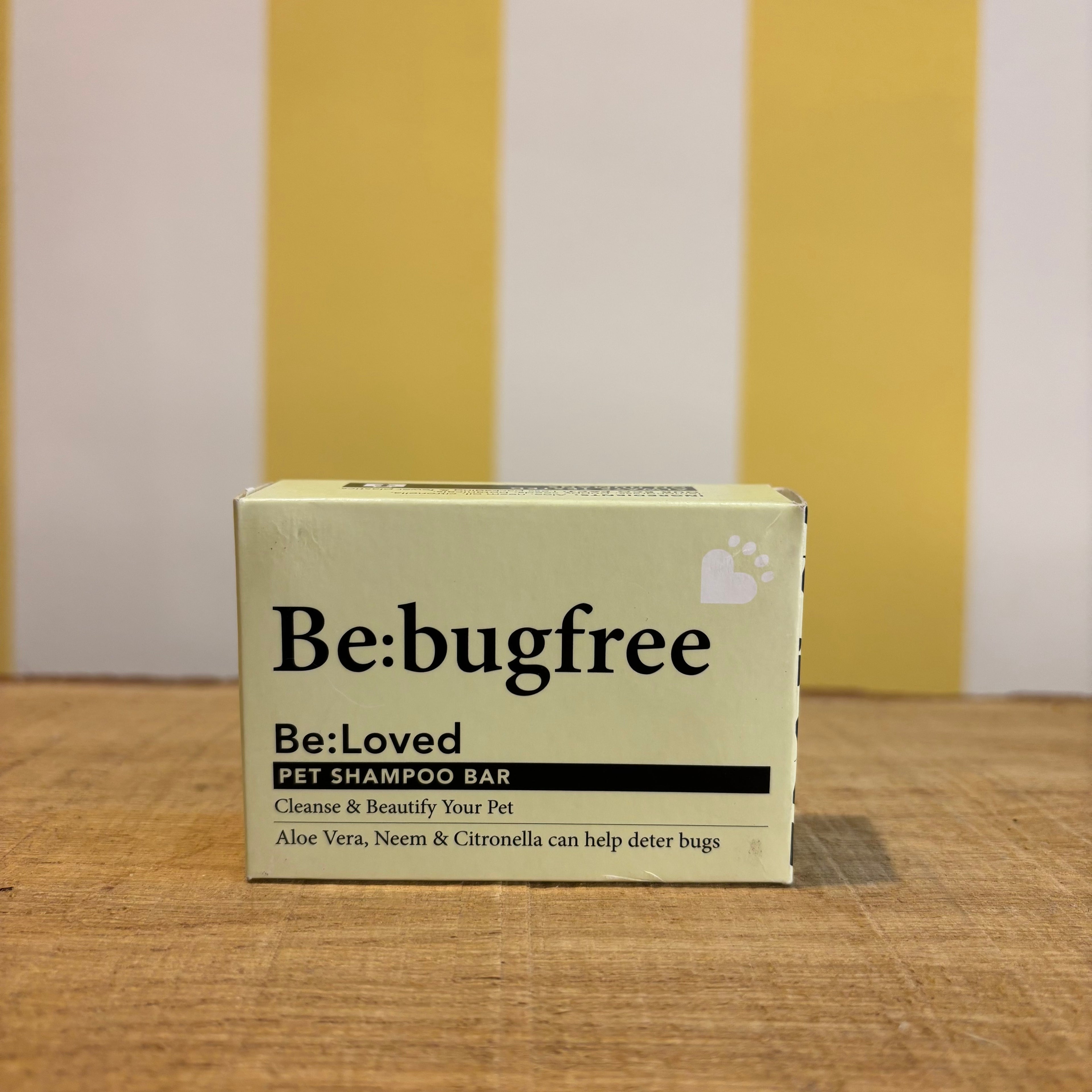 Three boxes of The Tetbury Pet Shop & Grooming's Be: Natural Shampoo Bars are stacked on wood with a yellow and white striped background, showcasing these eco-friendly pet shampoos.