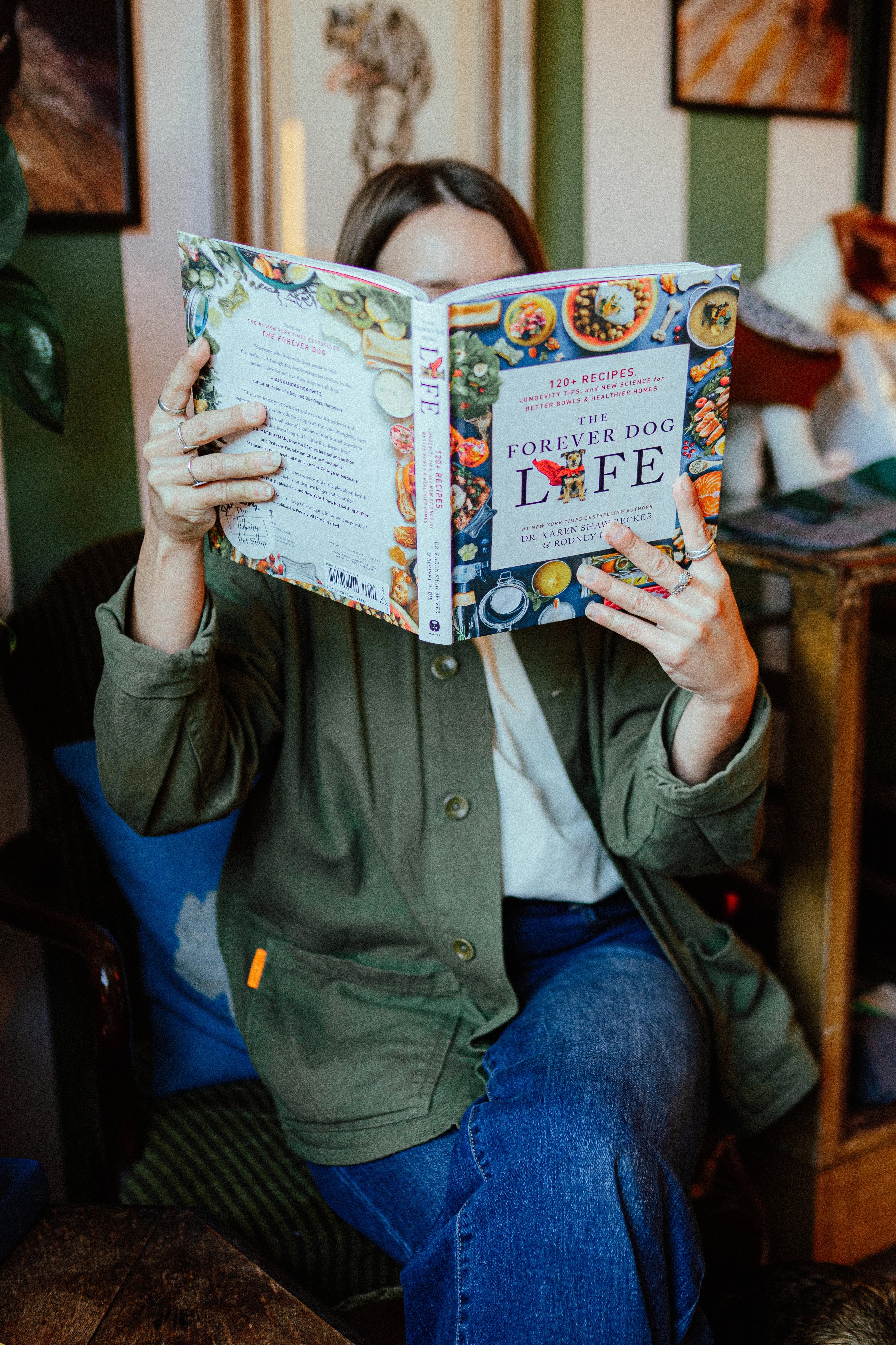 Dog expert reading a book titled 'Forever Dog Life' in a cozy pet shop.